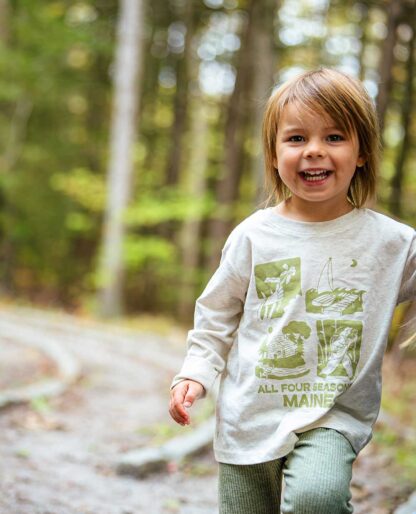 toddler smiling wearing NRCM long-sleeved tee